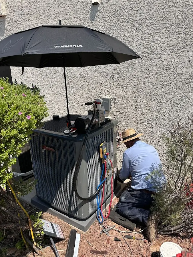 HVAC technician performing outdoor AC maintenance in Lake Havasu City